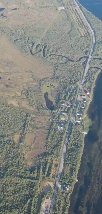 Aerial view of a coastal road with lush green surroundings and a river.