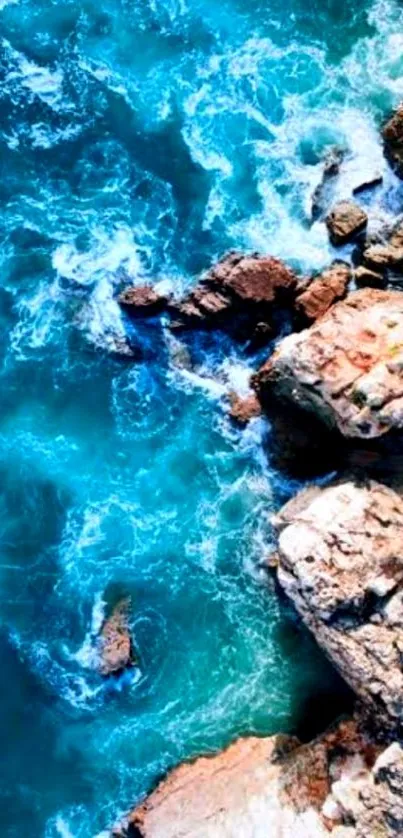 Aerial view of turquoise ocean waves hitting rocky coastline.