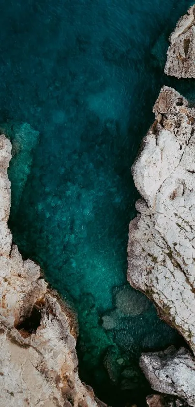 Aerial view of ocean and cliffs in teal hues.