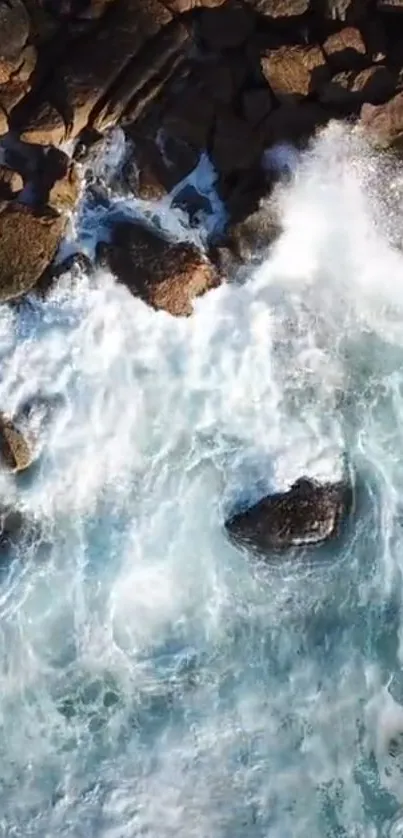 Aerial view of ocean waves crashing on rocky shores with light blue water.