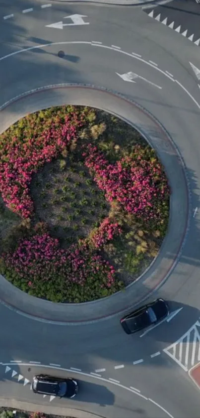 Aerial view of a roundabout with pink flowers in the center.