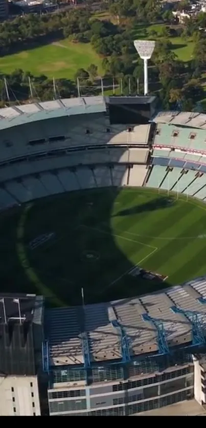 Aerial view of a green stadium surrounded by lush greenery.