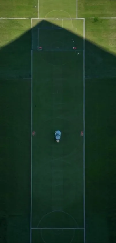 Aerial view of a soccer field with lush green grass and shadows.