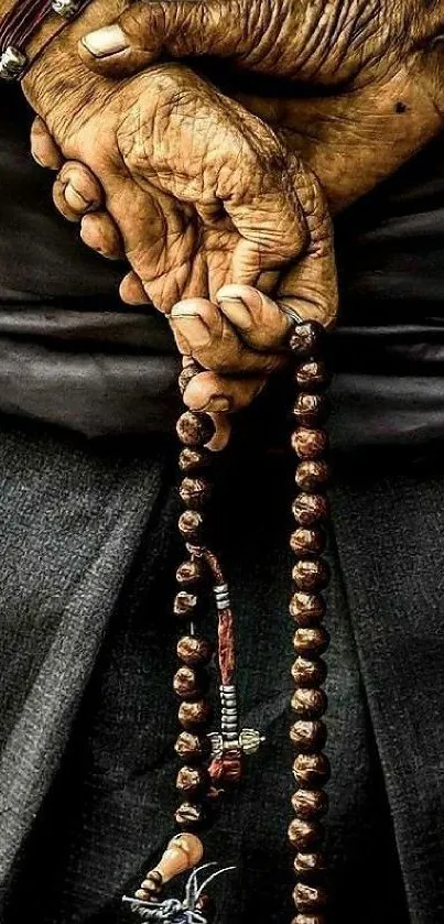 Aged hands holding long prayer beads, symbolizing spirituality.