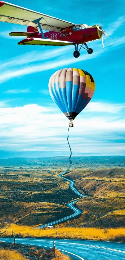 Plane towing a hot air balloon over a winding road under a blue sky.