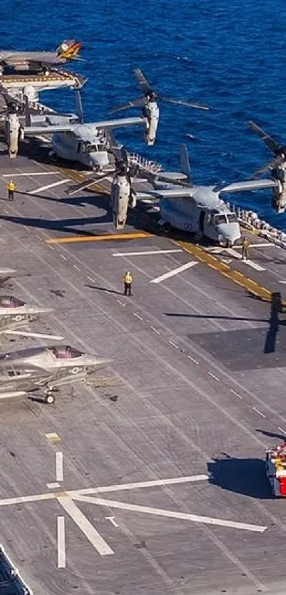 Aerial view of aircraft carrier with jets on deck over the ocean.