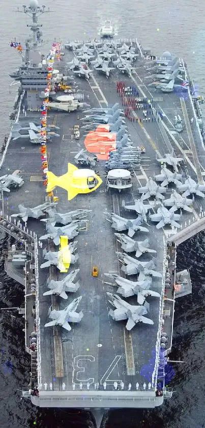 Aerial view of a massive aircraft carrier with planes on the deck at sea.