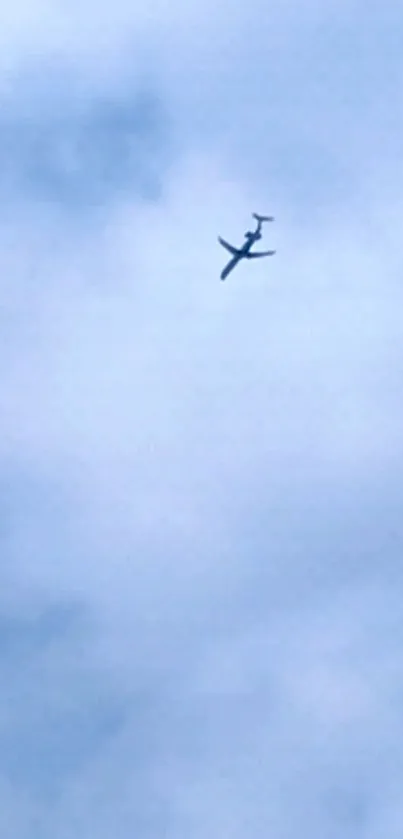 Airplane flying in a peaceful blue sky with clouds.