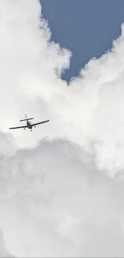 Airplane flying high amidst large white clouds in blue sky.