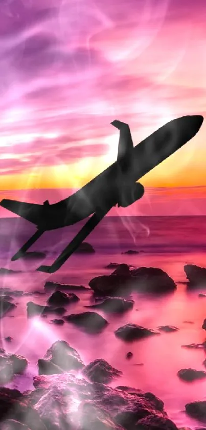 Airplane silhouette against a pink and purple sunset over a rocky seashore.
