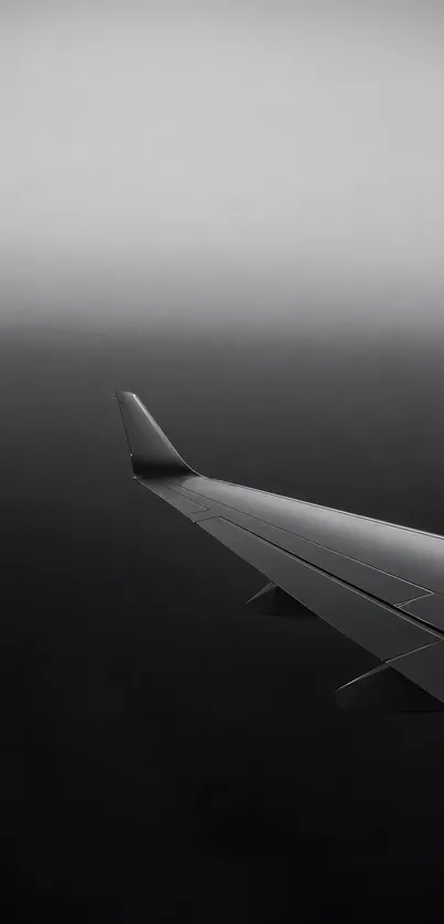 Airplane wing piercing through grey fog.