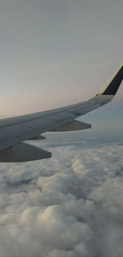 Airplane wing soaring above fluffy clouds in serene sky.