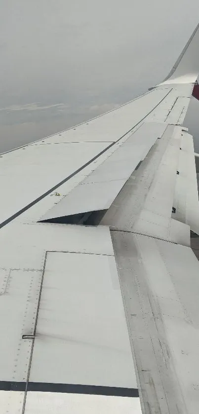 Aerial view from an airplane wing, overlooking clouds and landscapes.