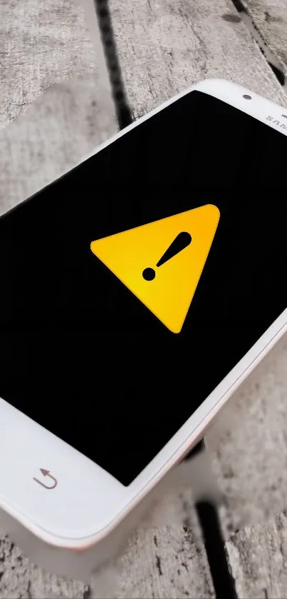 Smartphone wallpaper with yellow alert symbol.