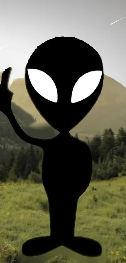 Silhouette of an alien in a lush green landscape with mountains.