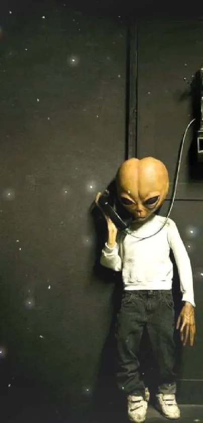 Alien in casual attire using a vintage payphone on a dark background.