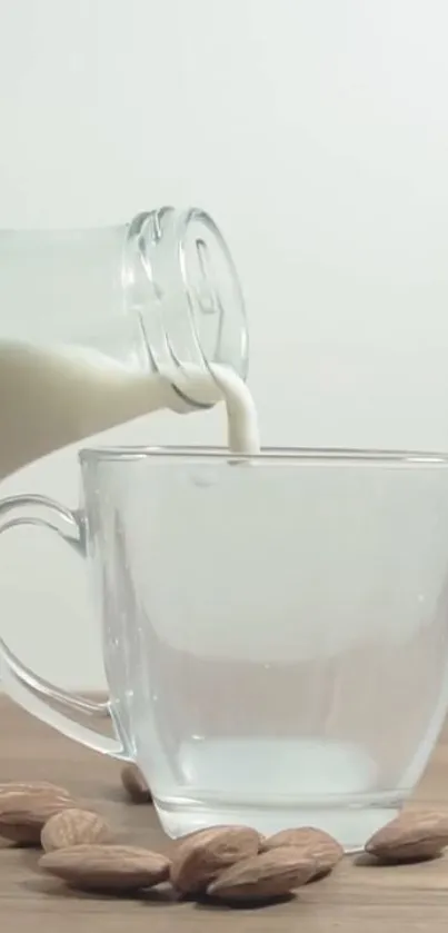 Almond milk pouring into a clear glass with scattered almonds.