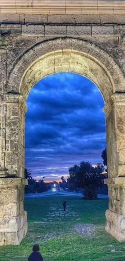 Stone archway against a vibrant blue sky at dusk.