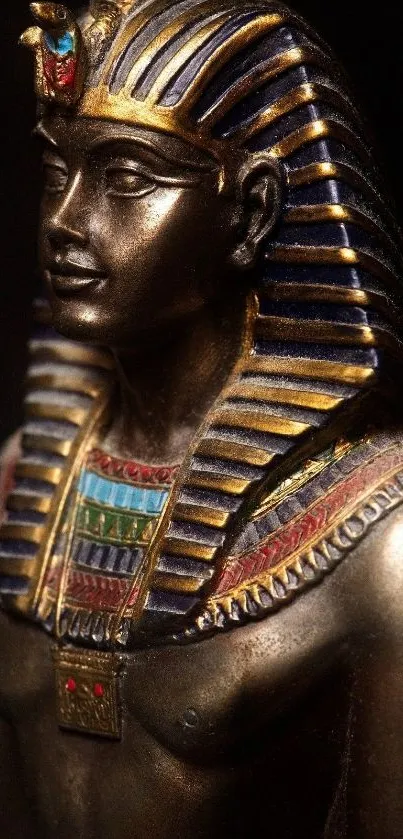 Gold statue of an Egyptian pharaoh with detailed headdress and ancient design.