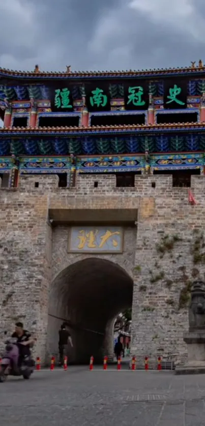 Ancient gate tower under a cloudy sky, showcasing traditional architecture.