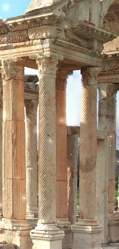 Ancient stone columns with carved details in a picturesque open setting.