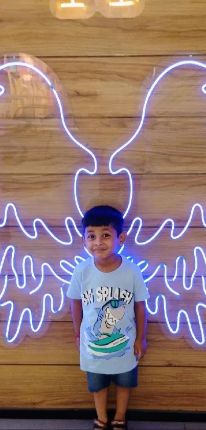 Child with glowing neon angel wings on wooden background.