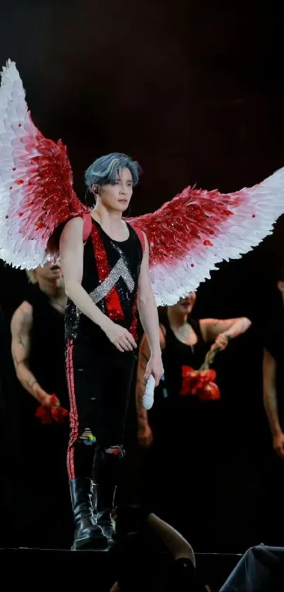 Performer with red and white wings on stage.