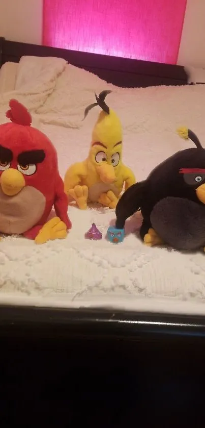 Plush Angry Birds toys lounging on a bed.