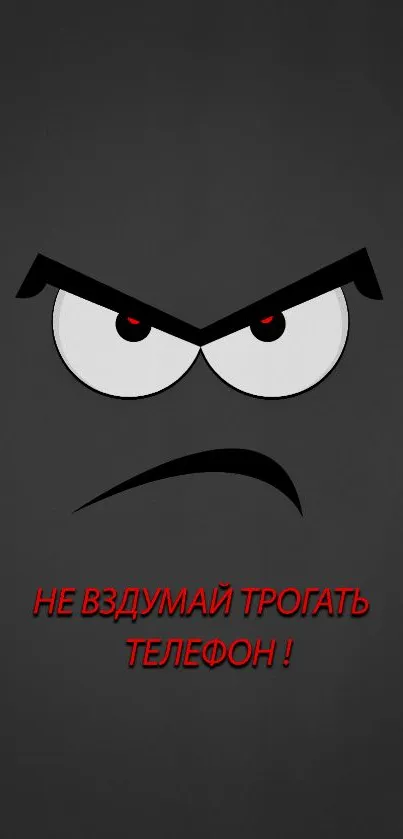 Minimalist angry face with red eyes on a charcoal gray mobile wallpaper.