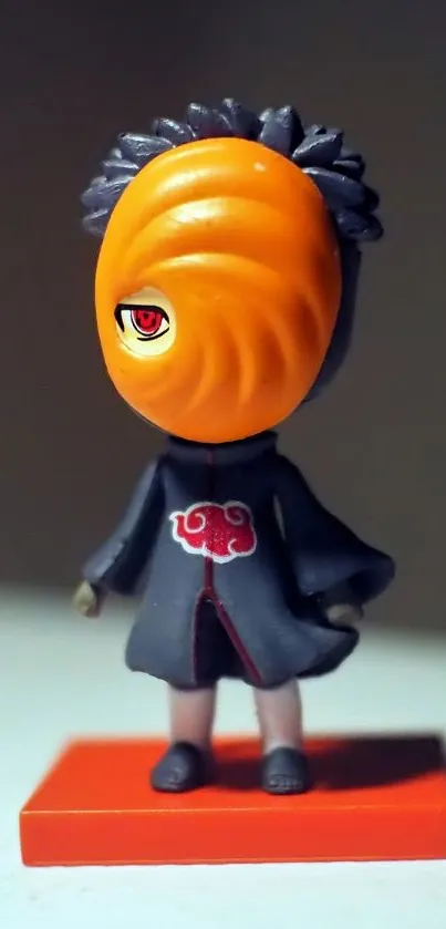 Anime figure with orange mask on display stand.