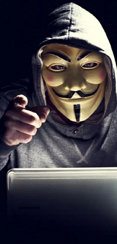 Masked figure showing anonymity on laptop.