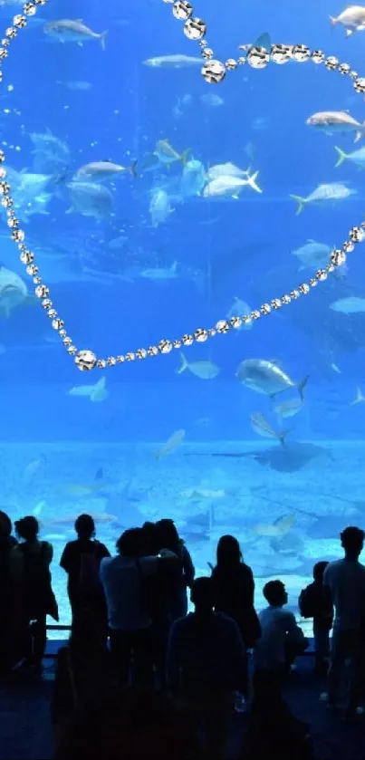 Silhouetted crowd watching an aquarium heart display.