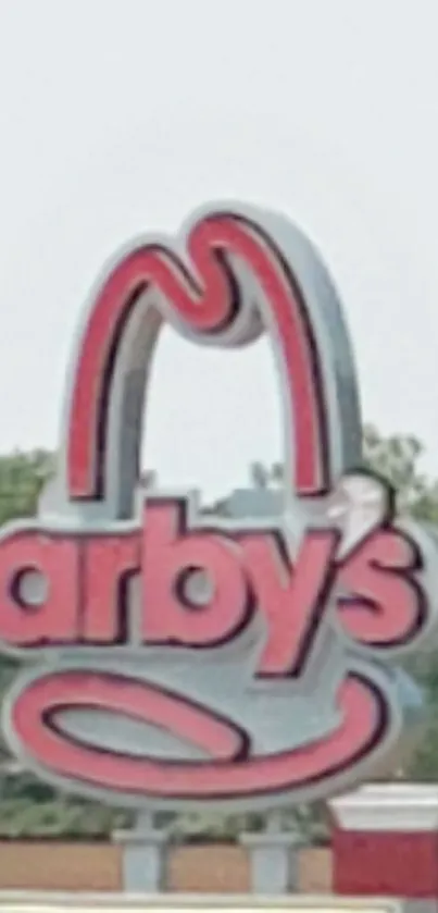 Vibrant red Arby's sign under a clear sky.