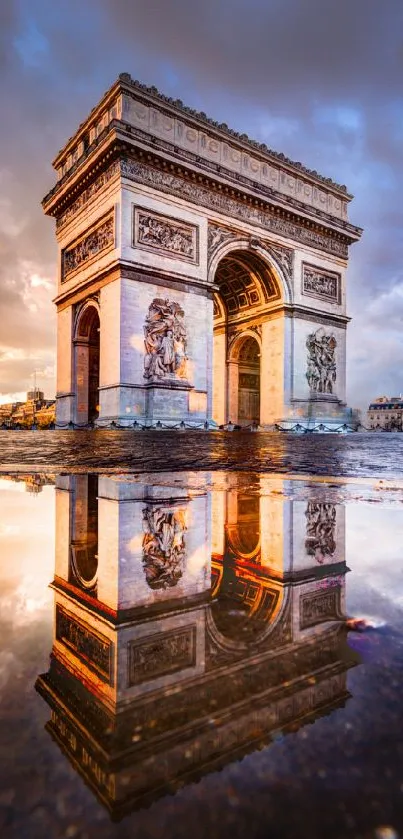 Arc de Triomphe reflecting in a puddle at sunset, with vibrant sky colors.