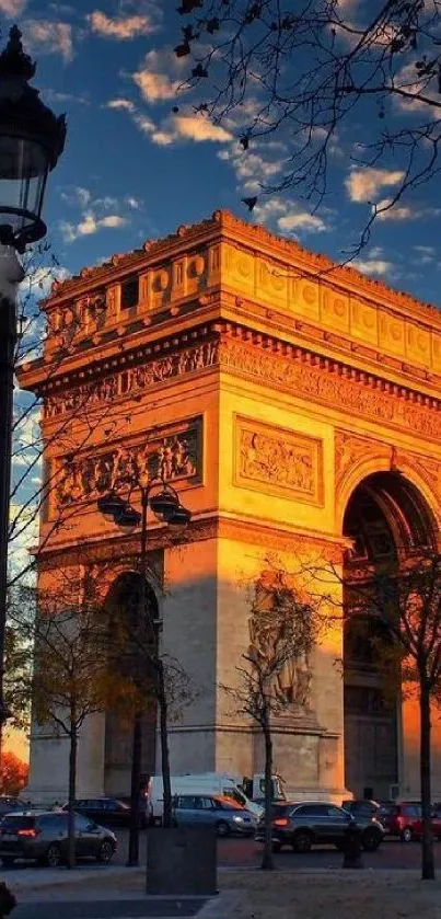 Arc de Triomphe at sunset with silhouetted trees and vibrant sky.