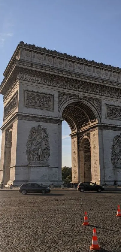 Arc de Triomphe under a clear blue sky with traffic.