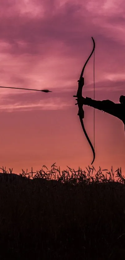 Silhouette of an archer at sunset with a vibrant pink sky.