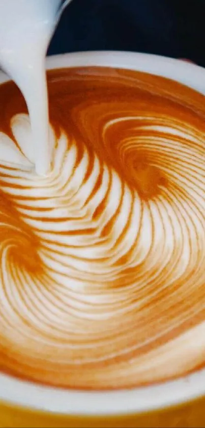 A yellow cup with intricate latte art foam design.