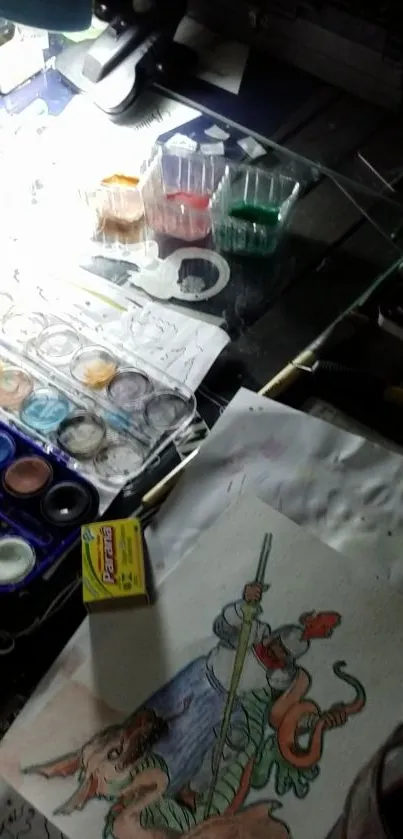 Creative workspace with art materials, watercolors, and sketch on a desk.