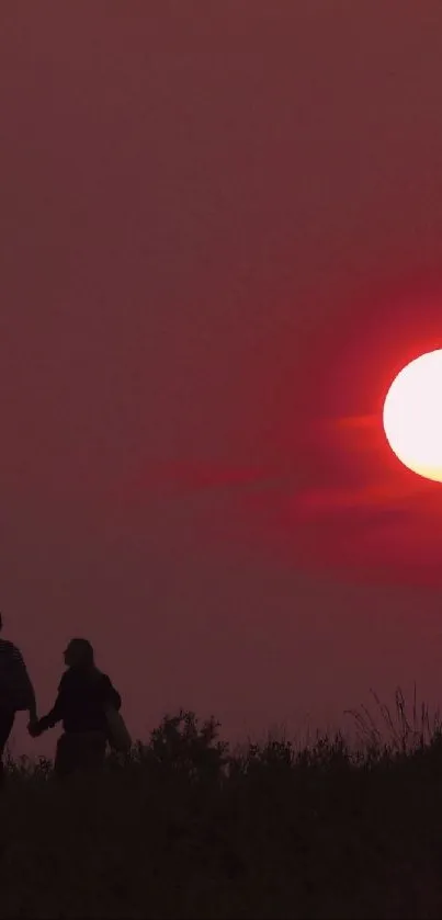 Couple silhouette with sunset over a red sky in a romantic, peaceful setting.