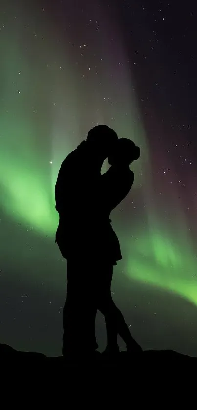 Silhouette of a couple under vibrant aurora borealis in night sky.