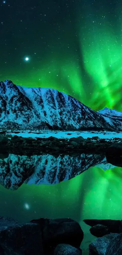 Aurora Borealis glowing over a snow-capped mountain reflected in a still lake.