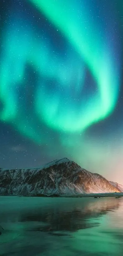 Aurora Borealis over snowy mountains and lake.