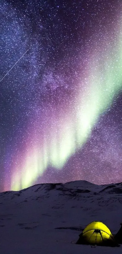 Aurora borealis over snowy landscape with tent under starry sky.