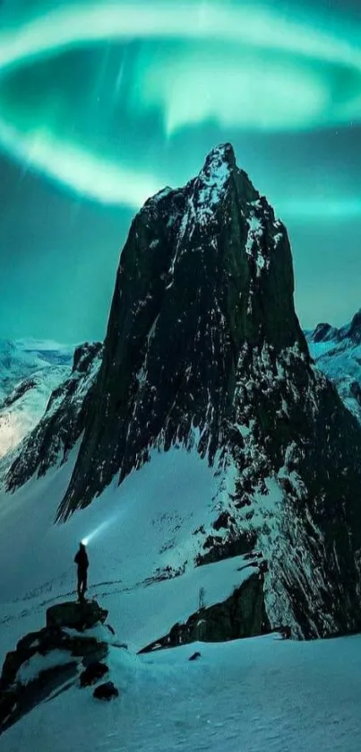 Stunning aurora over a snowy mountain peak, casting teal and white hues in the night.