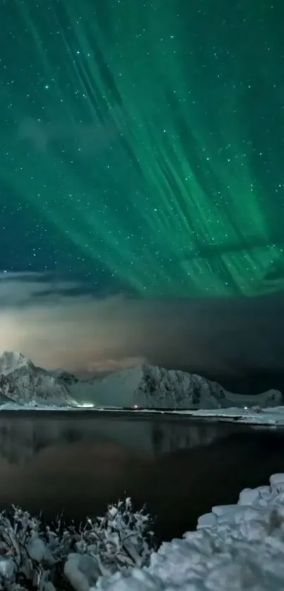 Northern lights over snowy mountains and serene lake.