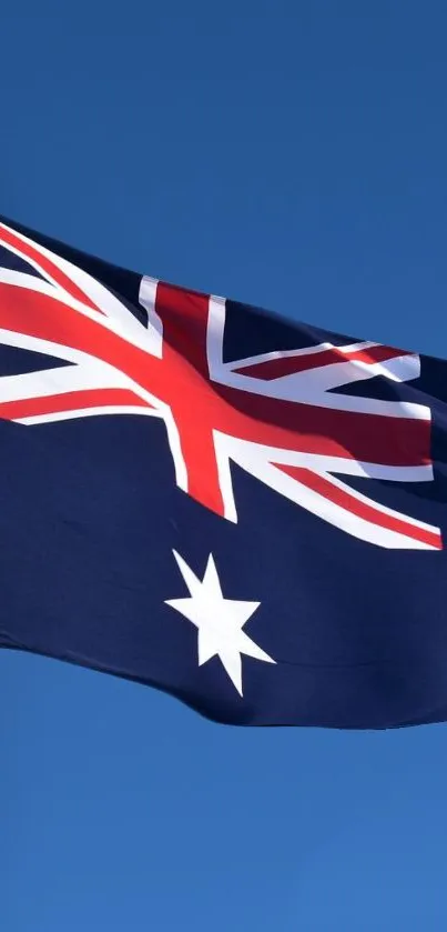 Australian flag waving against clear blue sky.