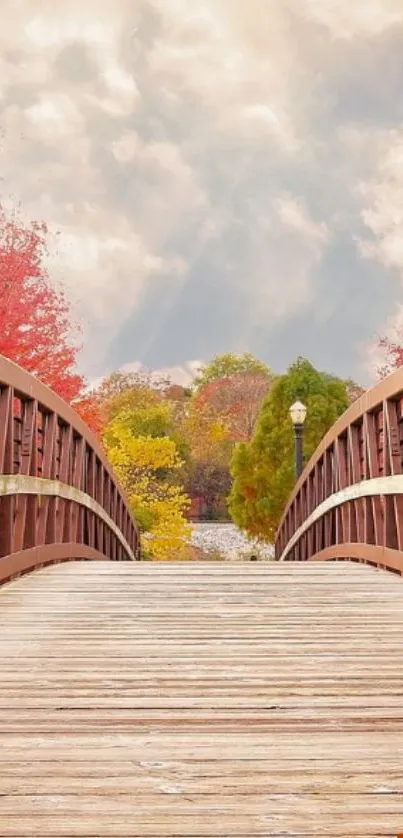 Bridge with autumn foliage under a cloudy sky.