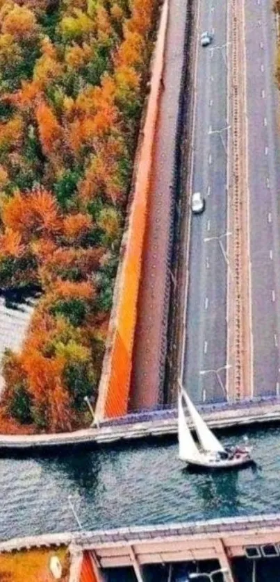 Aerial view of a bridge over a waterway in autumn, with vibrant foliage.