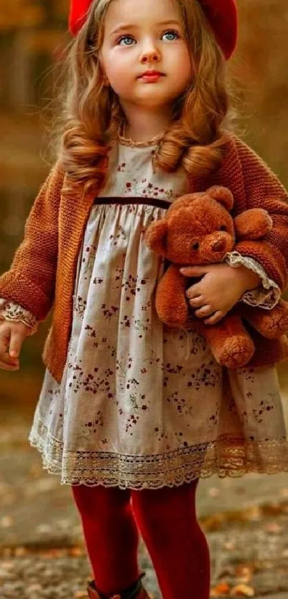 Little girl in autumn with teddy bear.